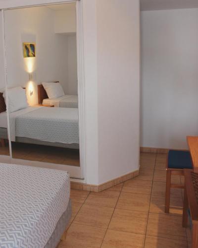 阿尔布费拉维加斯公寓的一间卧室配有两张床和镜子