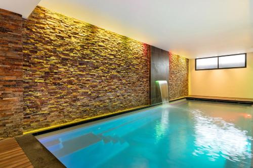 阿姆斯特丹Corendon Amsterdam New-West, a Tribute Portfolio Hotel的砖墙房间的游泳池