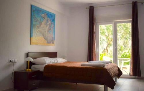 阿斯特里斯Thasos Seaside Serenity - Seaview & Garden Nests的一间卧室设有一张床和一个大窗户