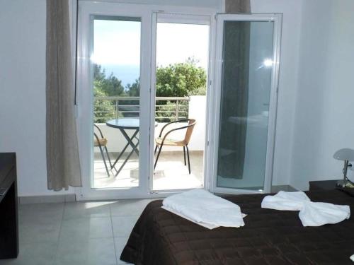 阿斯特里斯Thasos Seaside Serenity - Seaview & Garden Nests的一间卧室配有一张床,阳台配有桌子