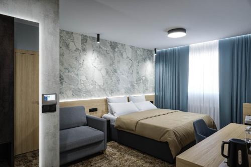 塞内奇Hotel Senec Aqua Resort的配有一张床和一把椅子的酒店客房