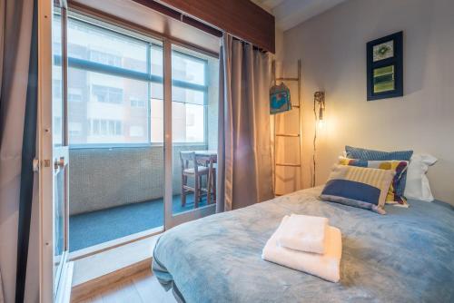 波尔图GuestReady - Woodwork Apartment的一间卧室设有一张床和一个大窗户