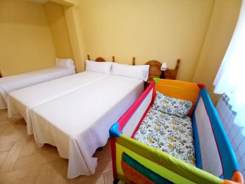 Velilla del Río CarriónHOTEL RURAL ORQUIDEA的一间卧室配有两张床和一张婴儿床。