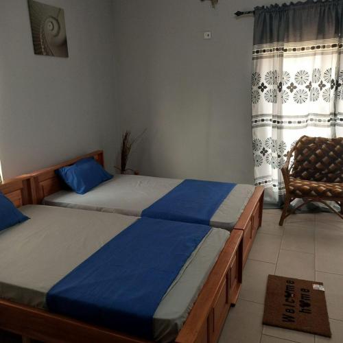 阿克拉Estepona Playa Hostel的一间卧室设有两张床、一把椅子和一个窗户。