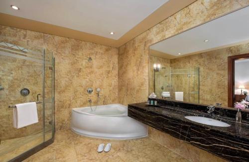 阿布扎比Al Raha Beach Hotel - Superior Room SGL - UAE的一间带浴缸和大镜子的浴室