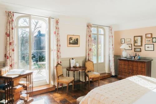 埃特勒塔Les Tilleuls Etretat的一间卧室配有一张床、一张书桌和两个窗户。