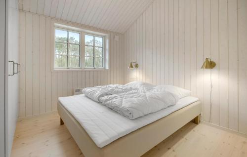维斯特索马肯Beautiful Home In Aakirkeby With Kitchen的一间卧室配有一张带白色床单的床和一扇窗户。