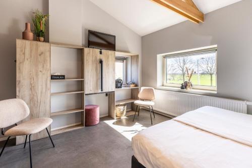 KolderwoldeWeeruusz的一间卧室配有一张床、两把椅子和一个窗户
