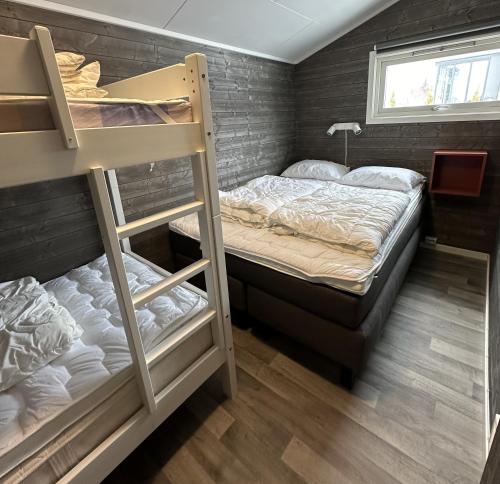 Gullor斯维斯特兰达露营地的一间卧室设有两张双层床和一扇窗户。