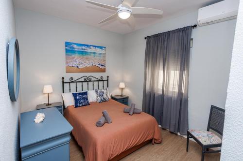 加的斯Apartamento Playa Santa María del Mar的一间卧室配有一张床和吊扇