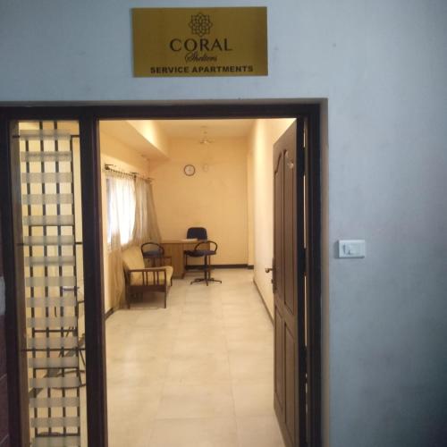 马杜赖Coral Shelters Keelavasal的走廊通往带桌椅的房间
