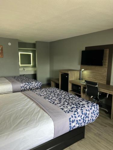 KennettEcono lodge Kennett的酒店客房配有一张床、一张书桌和一台电视。