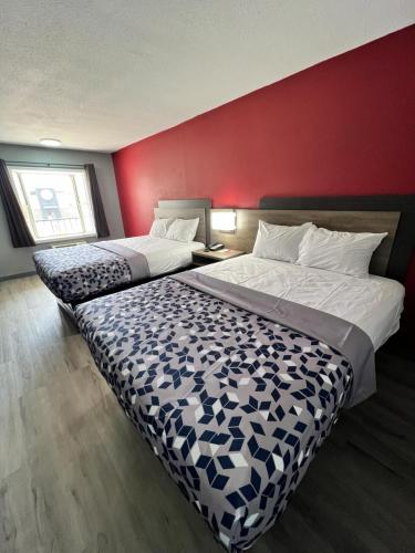KennettEcono lodge Kennett的酒店客房设有两张床和红色的墙壁。