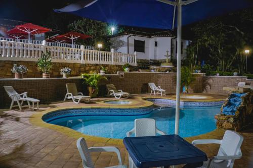 巴里查拉芬卡艾丽西亚别墅度假屋的游泳池在晚上配有椅子和遮阳伞