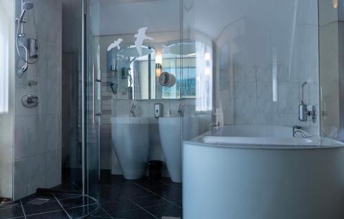 巴勒哈姆斯泰德托伦霍夫酒店的带淋浴、浴缸和盥洗盆的浴室