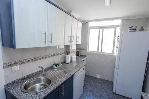 加的斯Apartamento Playa Santa María del Mar的厨房配有水槽和冰箱