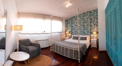 里贝拉Vila Sen Vento - Aguiño的一间卧室配有一张天蓬床和一把椅子