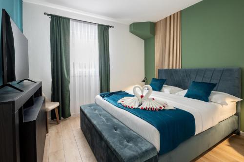 特罗吉尔VIPo Seget Apartments的一间卧室配有一张带天鹅装饰的床。