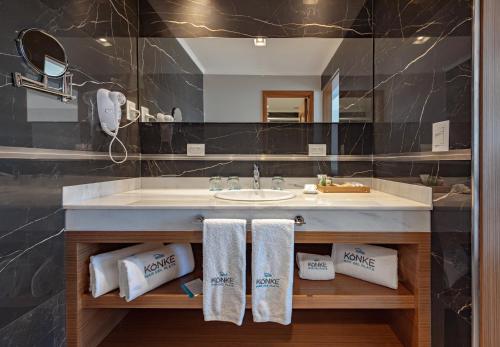 马德普拉塔HOTEL KONKE MAR DEL PLATA的浴室配有盥洗盆和带毛巾的台面。