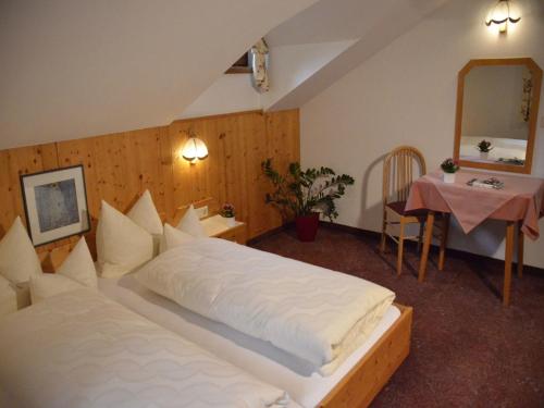 圣加伦基希Aparthotel Spitzer的卧室配有一张白色的大床和一张桌子