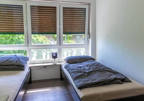 HeiligengrabeFirmen-Familien-Villa的一间卧室设有两张床和一个带百叶窗的窗户。