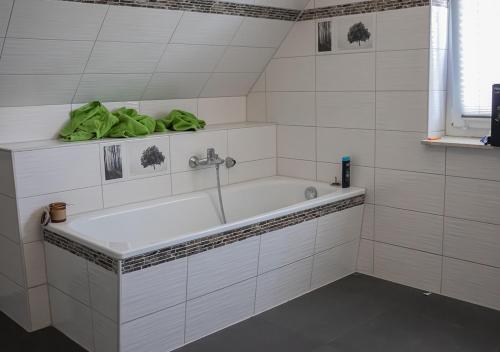 HeiligengrabeFirmen-Familien-Villa的带浴缸和绿毛巾的浴室
