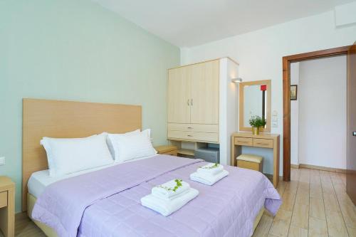 佩弗卡里Thassos ESPERIA HOTEL的一间卧室配有一张紫色床和两条毛巾
