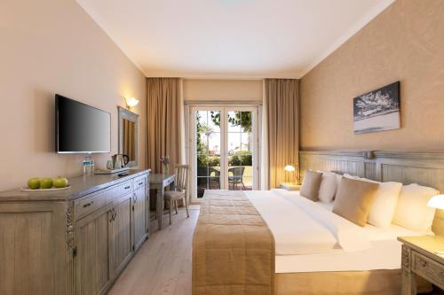 YumruAlaçatı Beach Resort的酒店客房设有一张大床和一台电视。