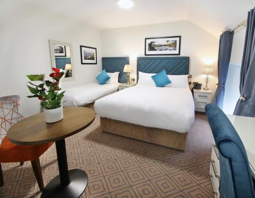 卡文The Bailie的酒店客房设有两张床和一张桌子。