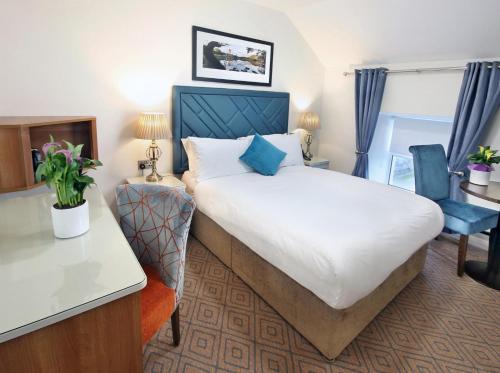 卡文The Bailie的酒店客房设有一张大床和一张书桌。