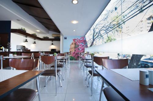 圣克鲁斯圣克鲁斯中心LP酒店 的餐厅设有桌椅和大窗户。