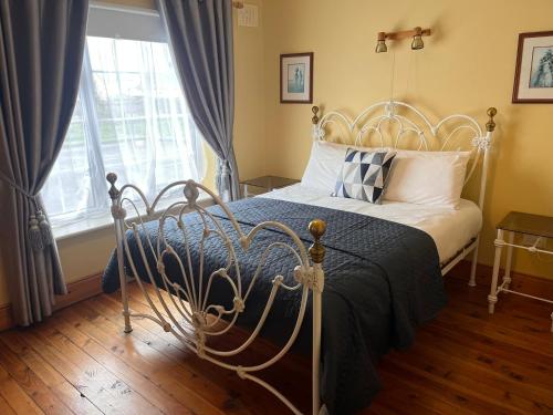 罗斯莱尔St Martin's, Rosslare Harbour Guest Accommodation的一间卧室设有一张床和一个窗口