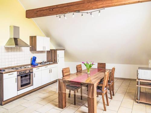 Greiveldange吉雷维丹吉公寓的厨房配有木桌和椅子