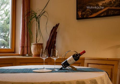 罗伊特GORI Boutique Apartments – Tirol的桌子上放有一瓶葡萄酒和两杯酒