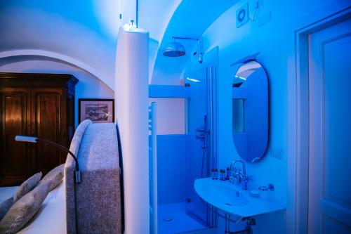 米诺利Antica Rheginna Luxury Room的蓝色的浴室设有床和水槽