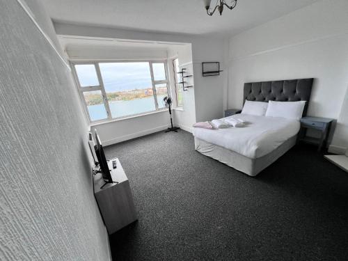 斯凯格内斯Harbour Flats的一间卧室设有一张床和一个大窗户