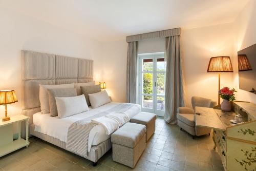 马拉泰亚桑塔维尼尔酒店的卧室配有一张白色大床和一把椅子