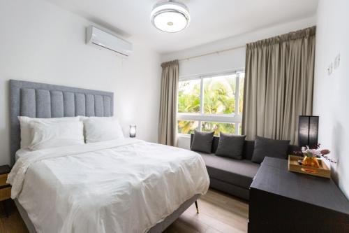 圣佩德罗-德马科里斯Villa At Metro Country Club With Private Pool的卧室配有一张白色的大床和一张沙发。