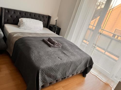 奥格斯堡Gemütliches 1 Zimmer Apartment的一间卧室配有一张带黑色毯子的床和窗户。