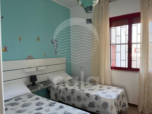 托雷拉皮罗Bella Vita - Piano Primo的蓝色墙壁客房的两张床