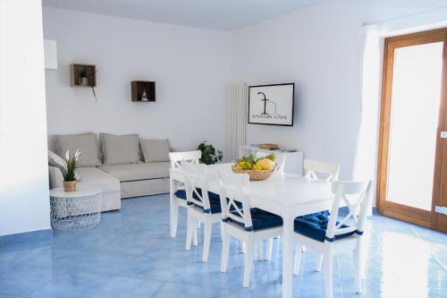 圣安吉洛Fountain House Sorrento的白色的用餐室配有白色的桌椅