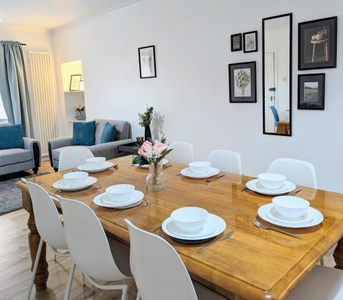 坎贝尔城Erradale的一间带木桌和白色椅子的用餐室