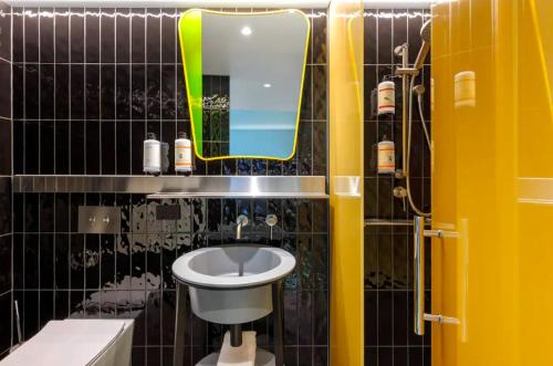悉尼Adge Hotel and Residence - Adge King - Australia的一间带水槽、镜子和卫生间的浴室