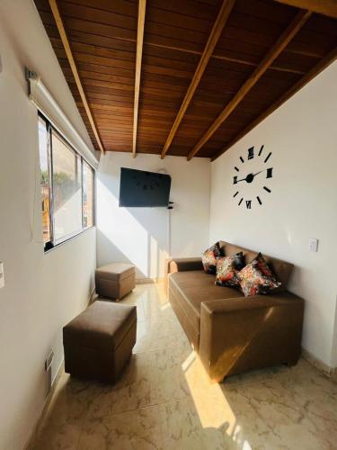 麦德林El Noral的客厅配有沙发和墙上的时钟