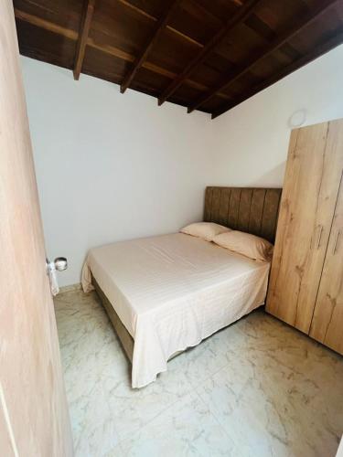 麦德林El Noral的一间卧室配有一张床和一个木制橱柜