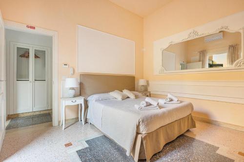 莱切Dimora Le Tre Muse Guesthouse的卧室配有一张床,墙上设有镜子