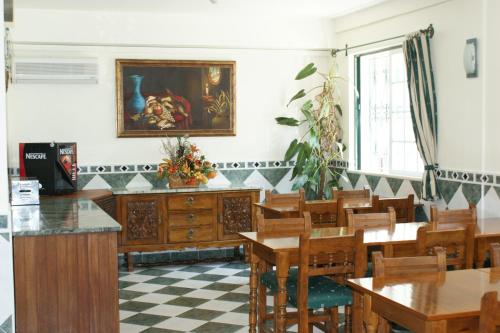 阿尔布费拉VilaBranca的用餐室配有桌椅,墙上挂有绘画作品