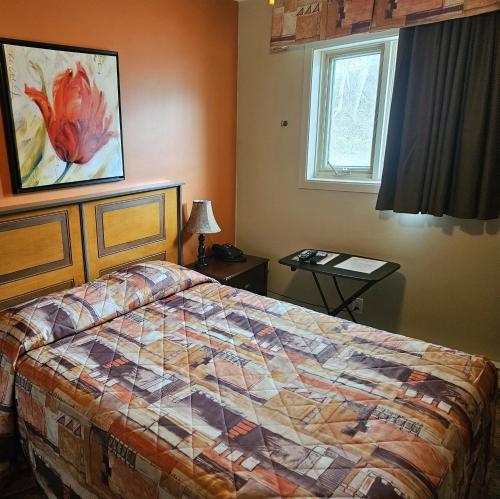 里穆斯基Motel Au Soleil couchant的一间卧室设有一张床和一个窗口