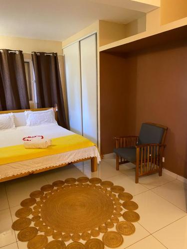 KoungouMaison Villa Dagoni的一间卧室配有一张床、一把椅子和地毯