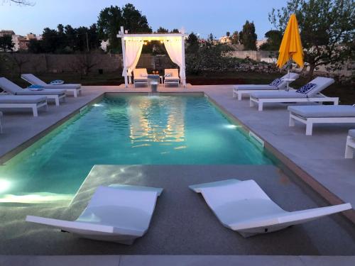 斯佩基亚B&B Casa Karina Pool&Rooms的一个带躺椅和凉亭的游泳池